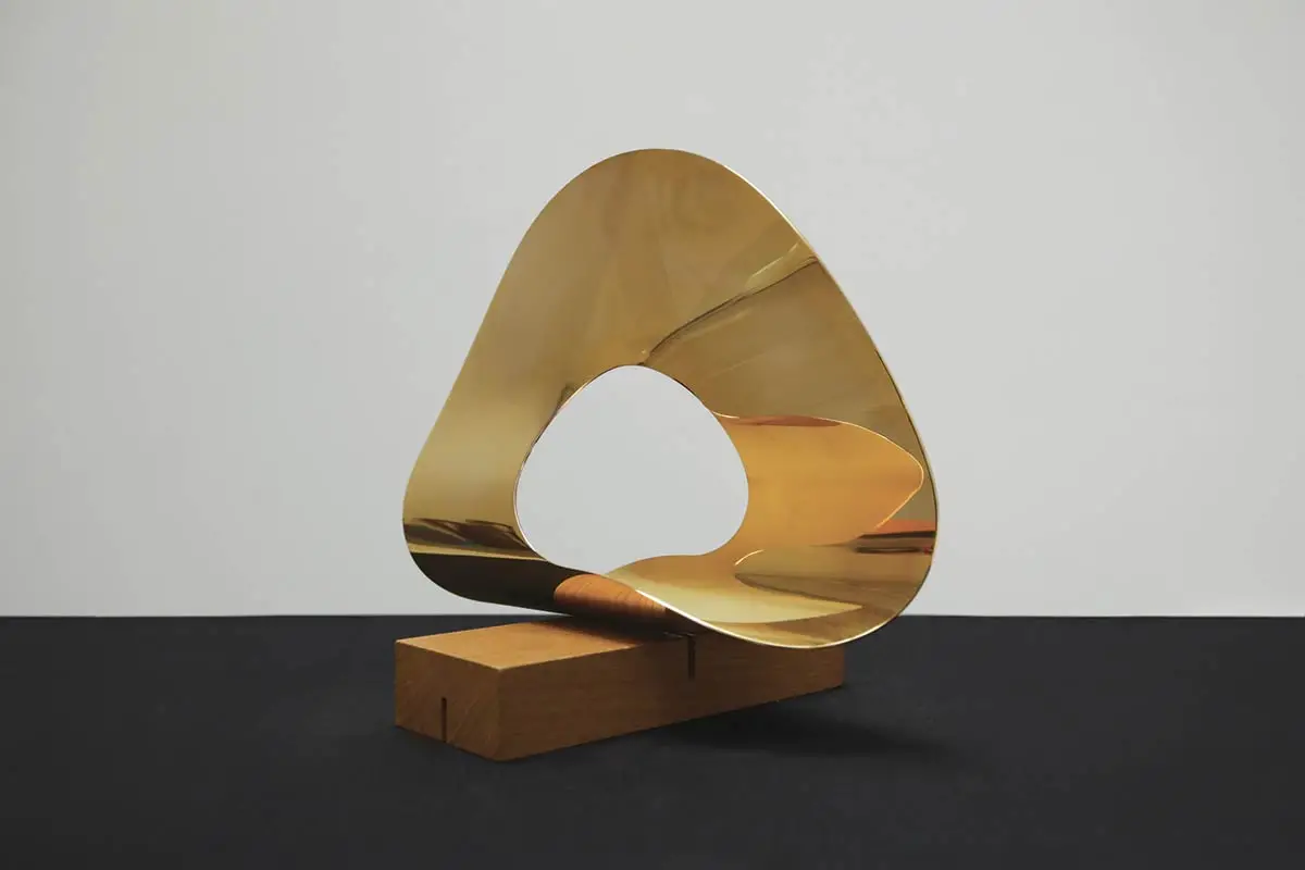 La scultura in ottone dorato unendliche schleife aus einem kreisring II, 1947-48, 37 x 9 x 27 cm, Collezione Lorenzelli Arte, Milano. © max, binia + jakob bill stiftung/2026, ProLitteris, Zürich